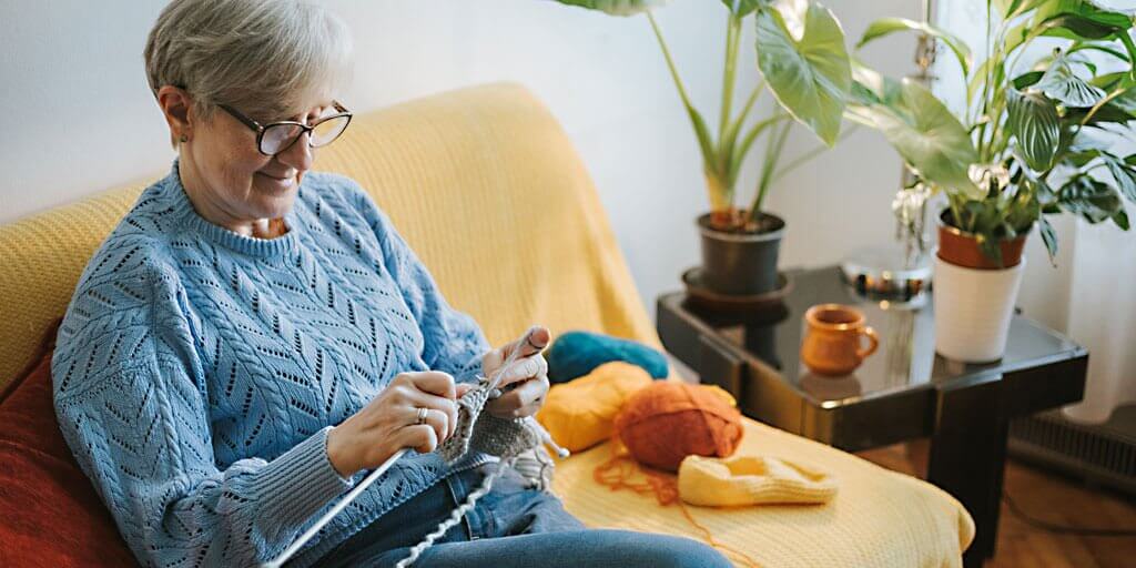Blog - Corneal Eye Care At a Glance A senior woman with eyeglasses is knitting.