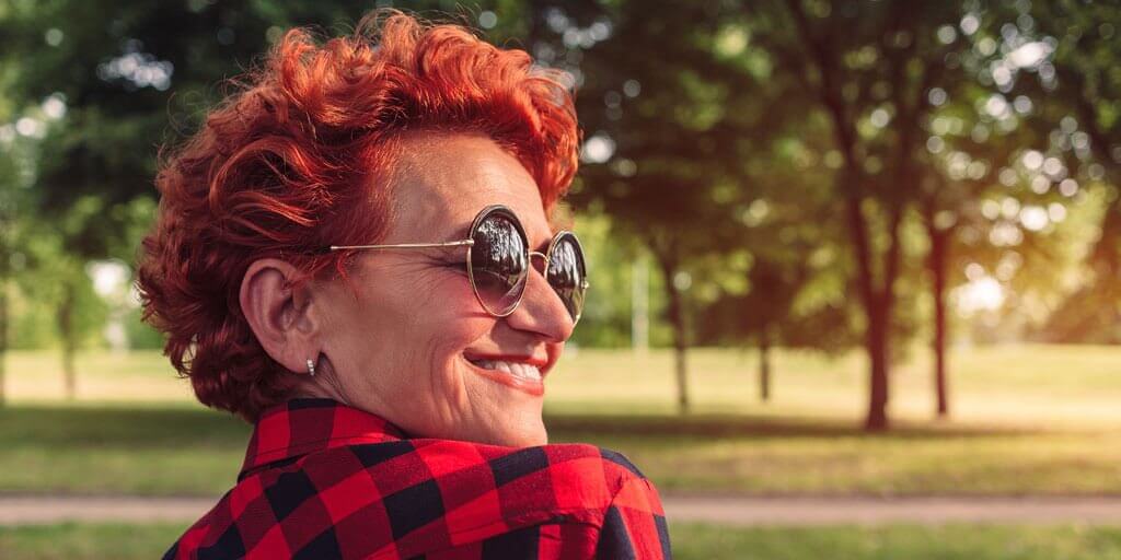 What can you do-cataracts A middle-aged woman outside wearing sunglasses to protect her eyes from the sun.