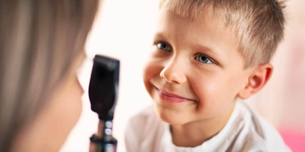 What-to-know-about-Pediatric-Ophthalmology-1024x512 A young boy getting an eye exam from his eye doctor.